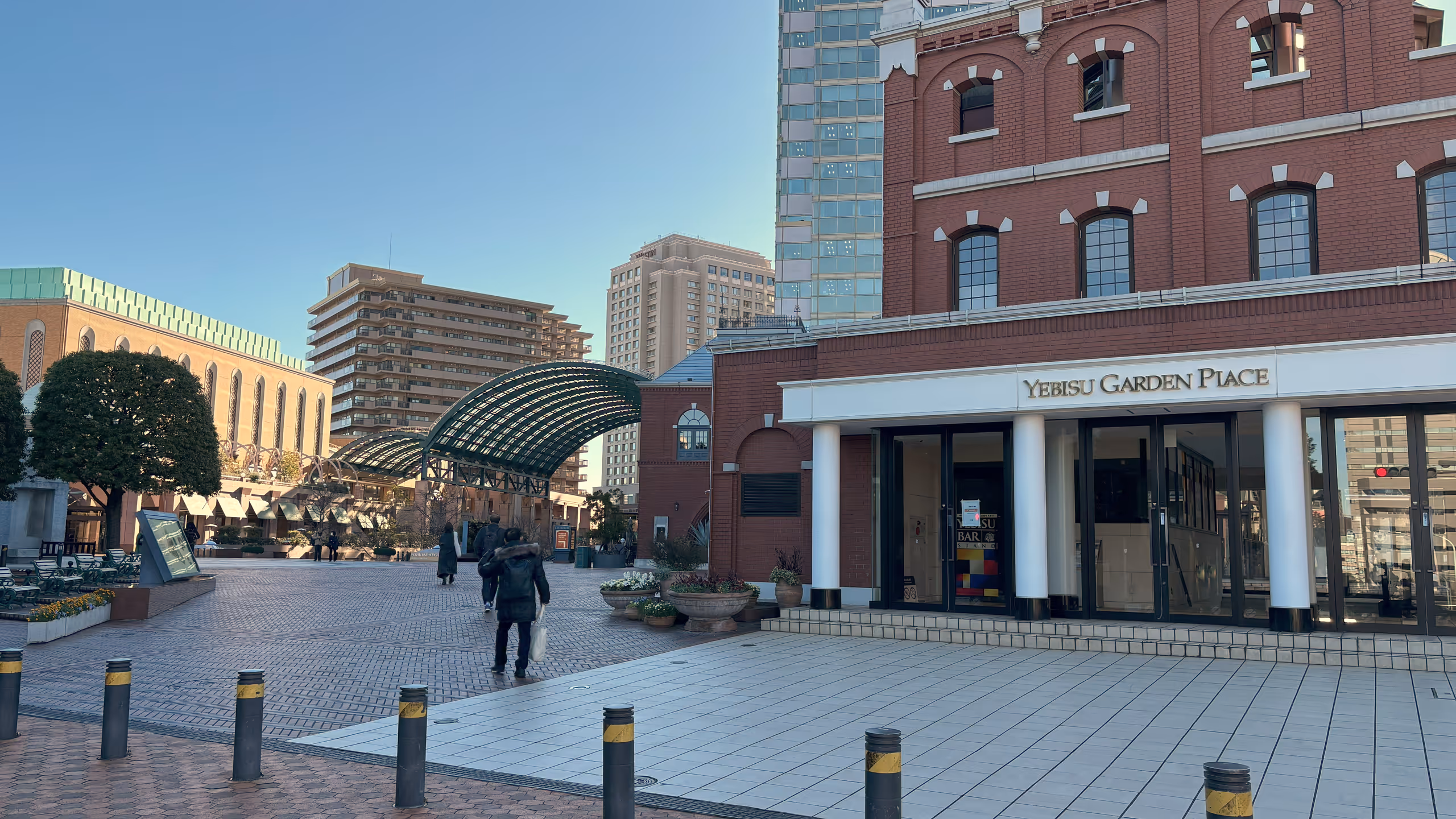 広場の右手に、大きな赤いレンガ造りの建物がある。その入り口に白い張り出しがあり、4本ほどの円柱の飾りで支えられており、欧風の建物らしい作りだ。広場を囲む他の建物も同じような作りで、統一感がある。