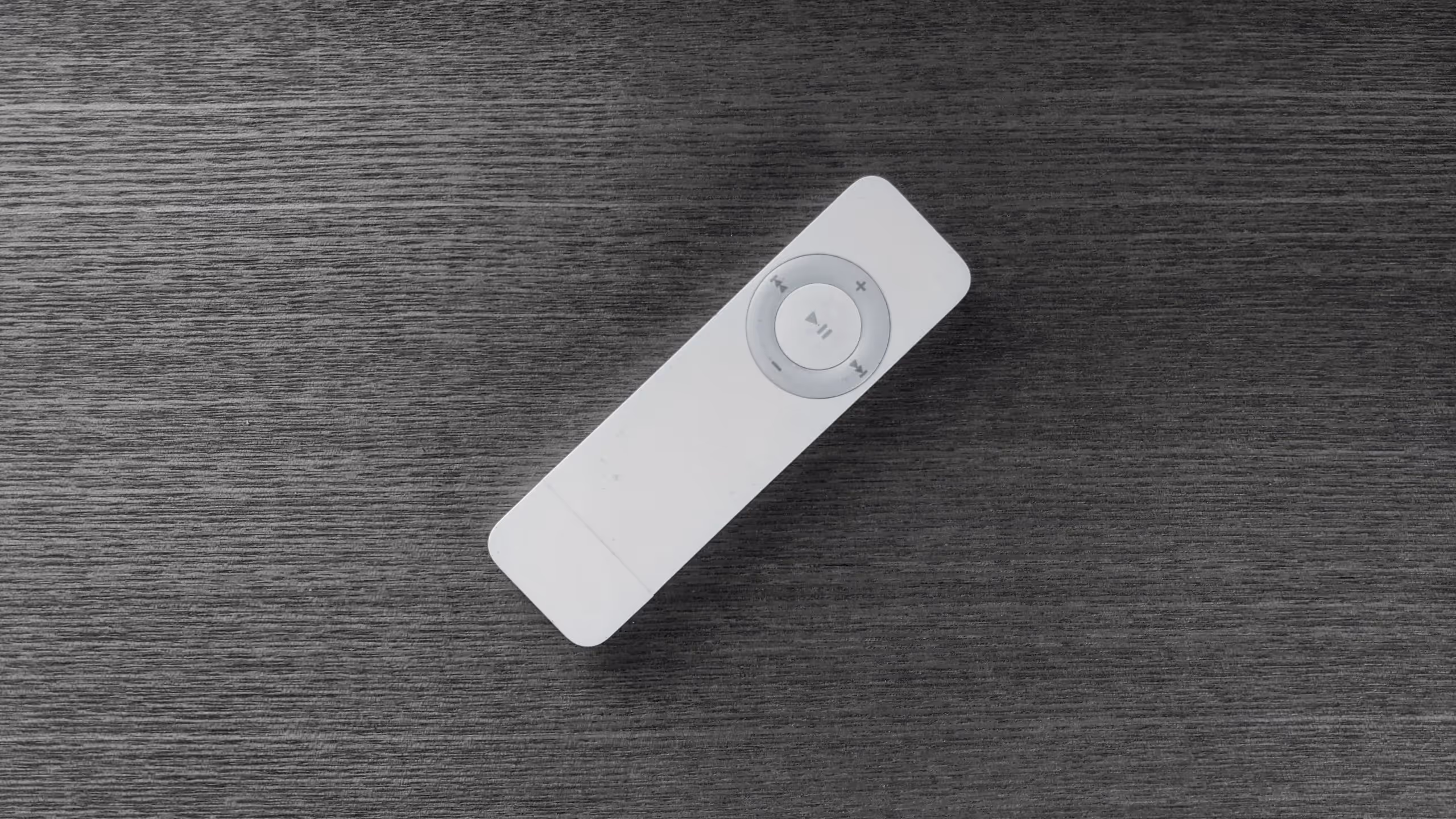初代iPod shuffle、白いガム型の筐体に、再生や、早送り、音量操作のボタンが配置されているだけだった