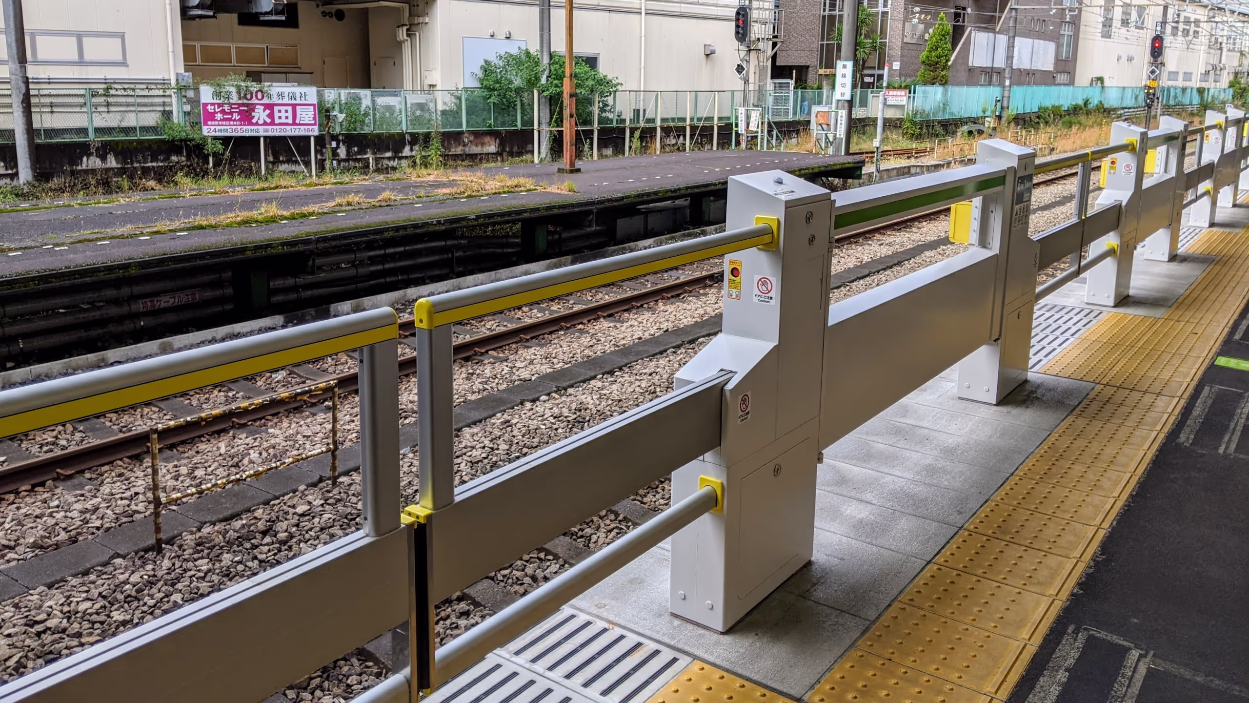 隙間から子供が落ちそうな、あまり見ないバー・タイプのホームドアがホームに設置されている