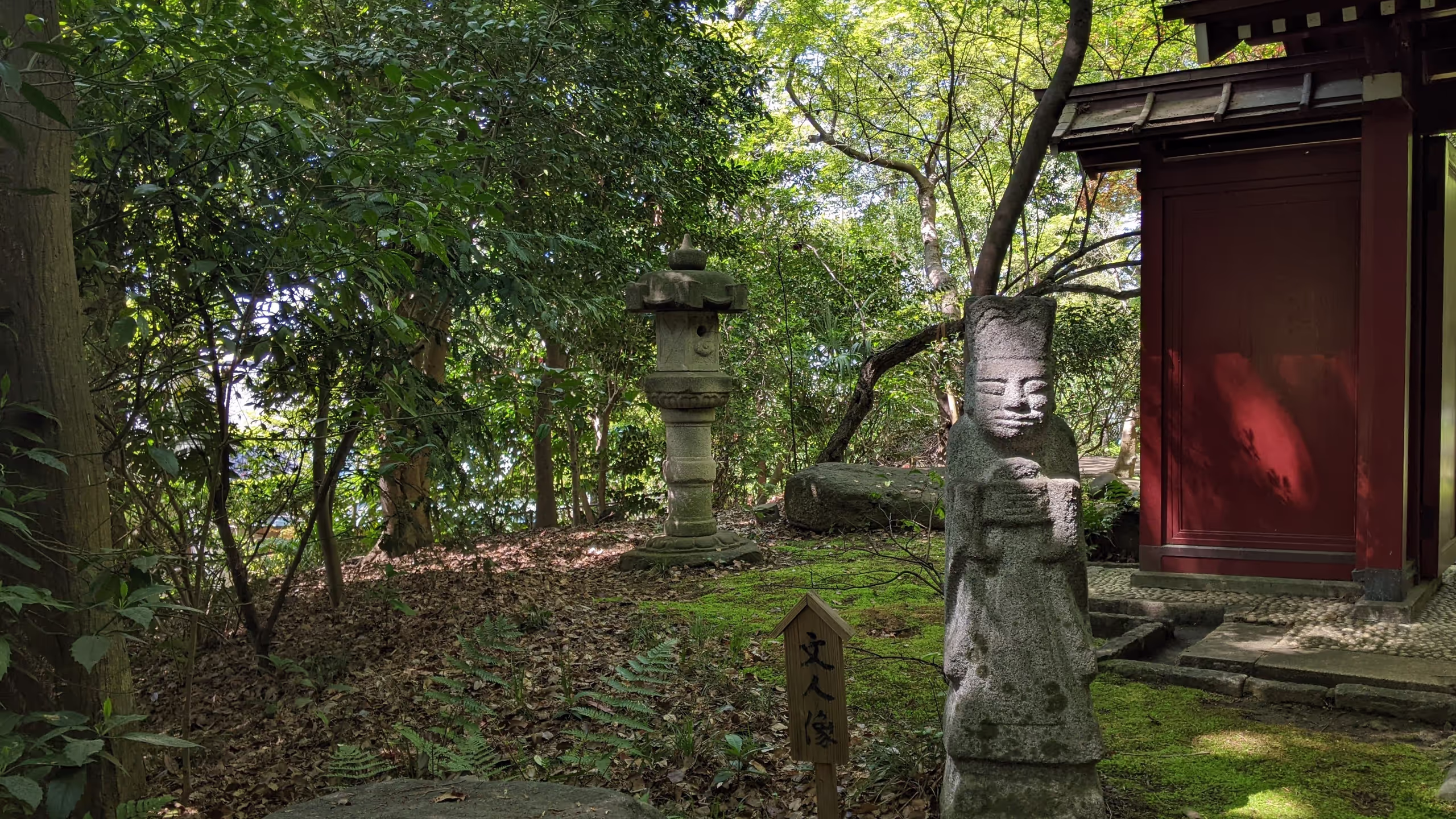 庭園中ほどにある少しだけ開けた場所には小さな石像があり、木漏れ日がその顔にかかっている