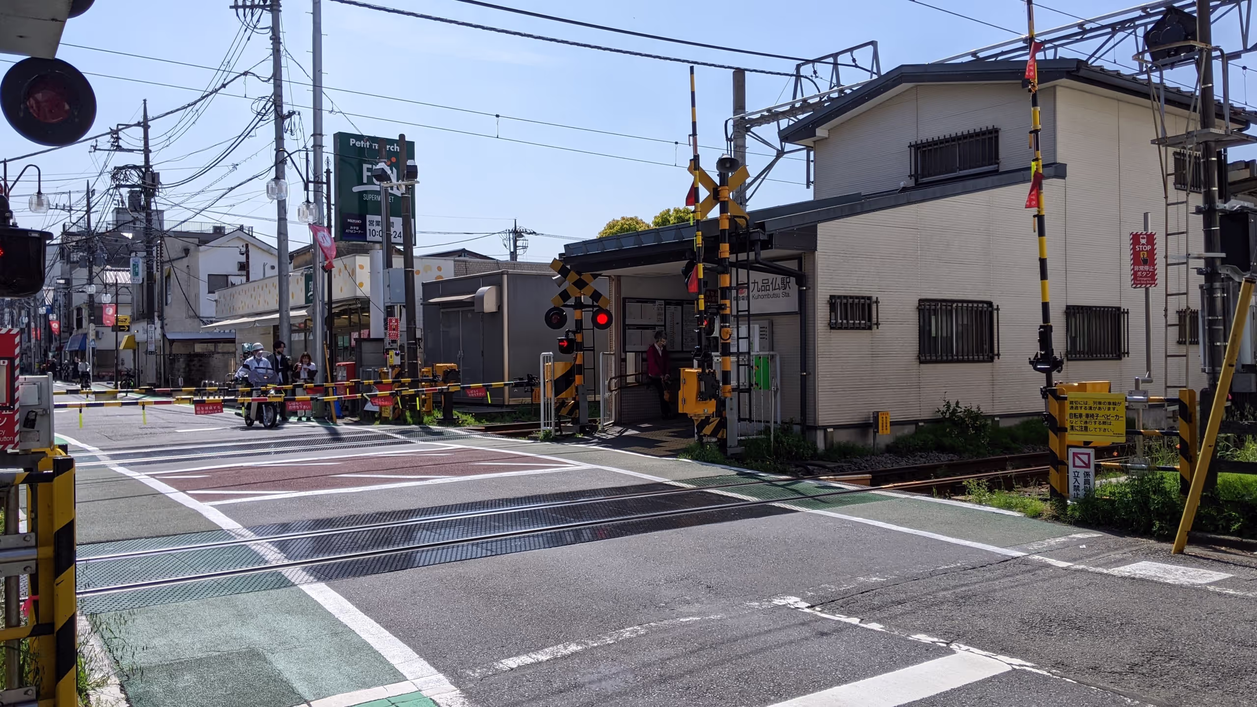 線路と線路の間に駅の出口があり、踏切に挟まれている