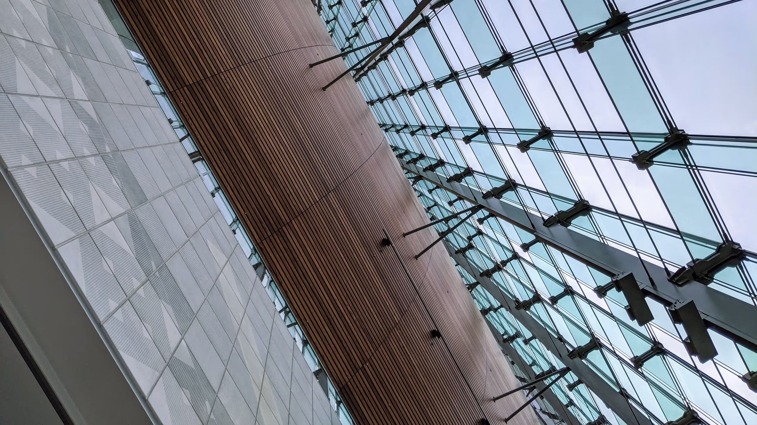 NeWoMan横浜のエントランスには、4フロア分くらいの吹き抜けがあり、見上げるとタイルと木材、ガラスが共演している。