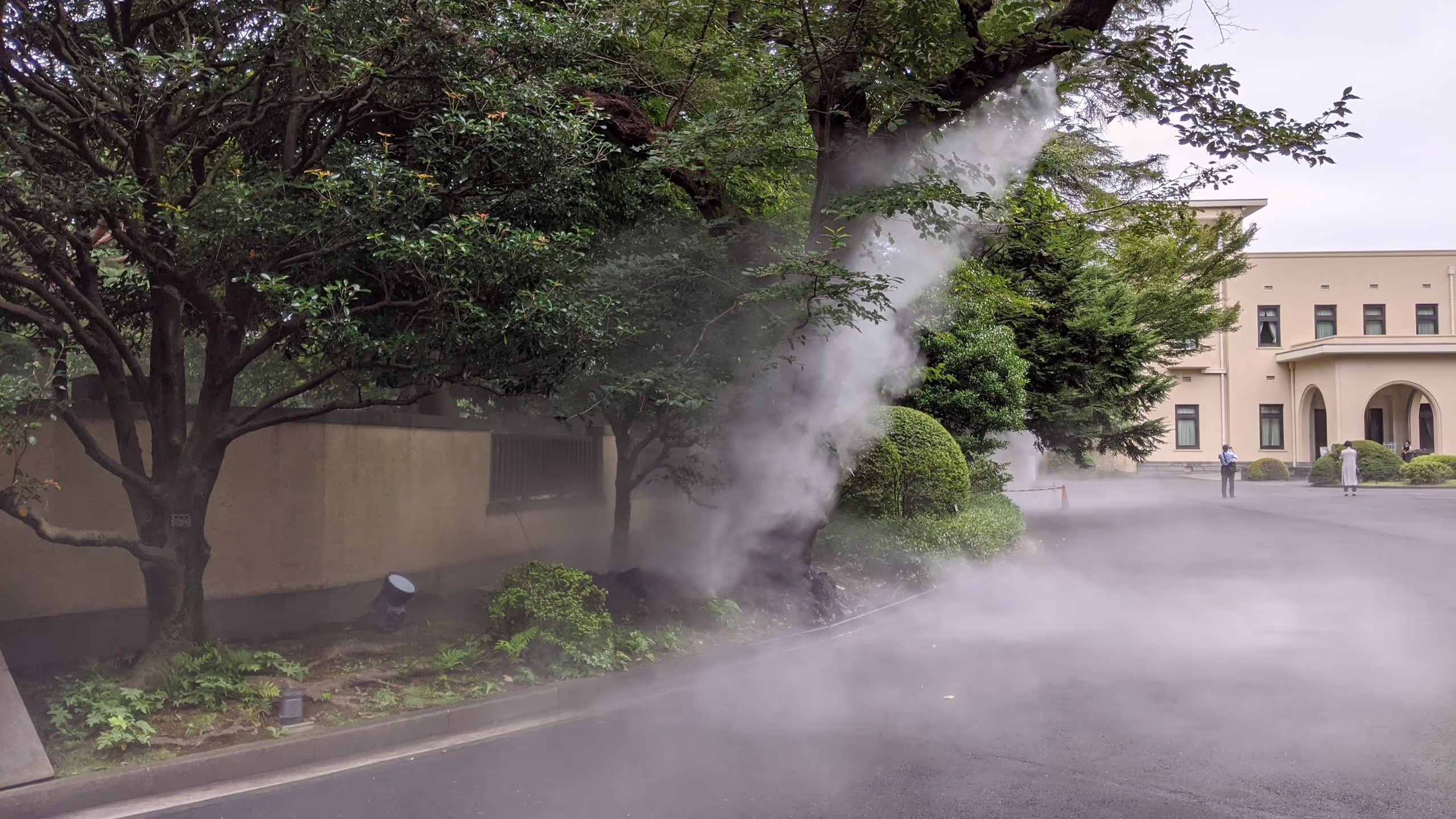 庭園入り口脇の樹木から、涼を取るために水が噴霧されている。