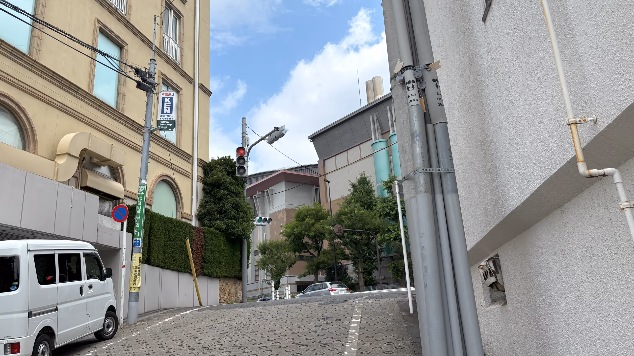 ややきつい傾斜の坂道は滑り止めの丸いくぼみが一面に施されている。登りきったところにある信号機は縦型で、なかなか珍しい。