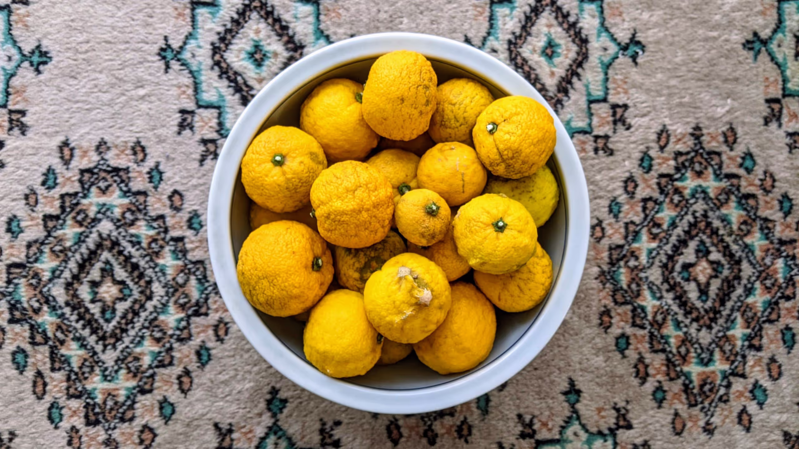 陶器の鉢にゆずがパンパンに詰まっている